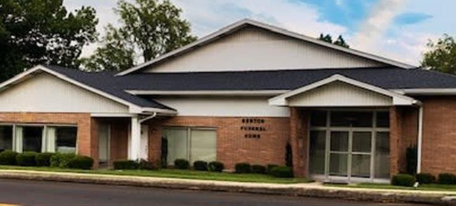 A large brick building with a white trim and a black roof.