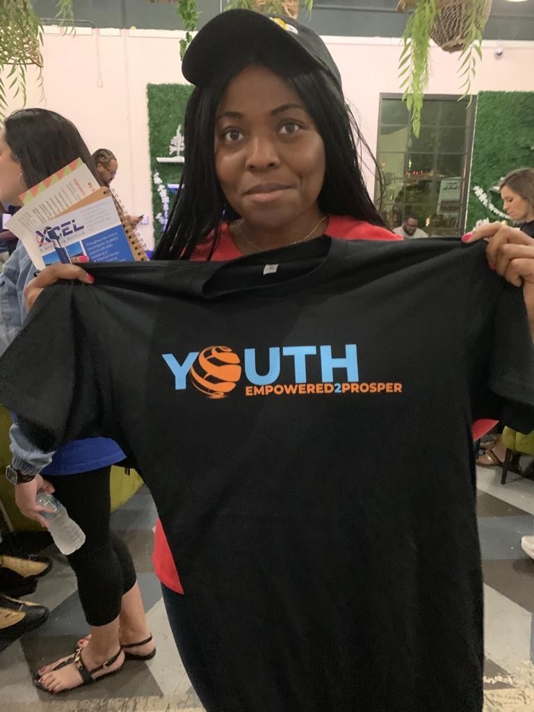 woman holding up a black tshirt that says 