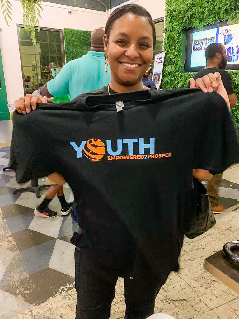 woman holding up a black tshirt that says 