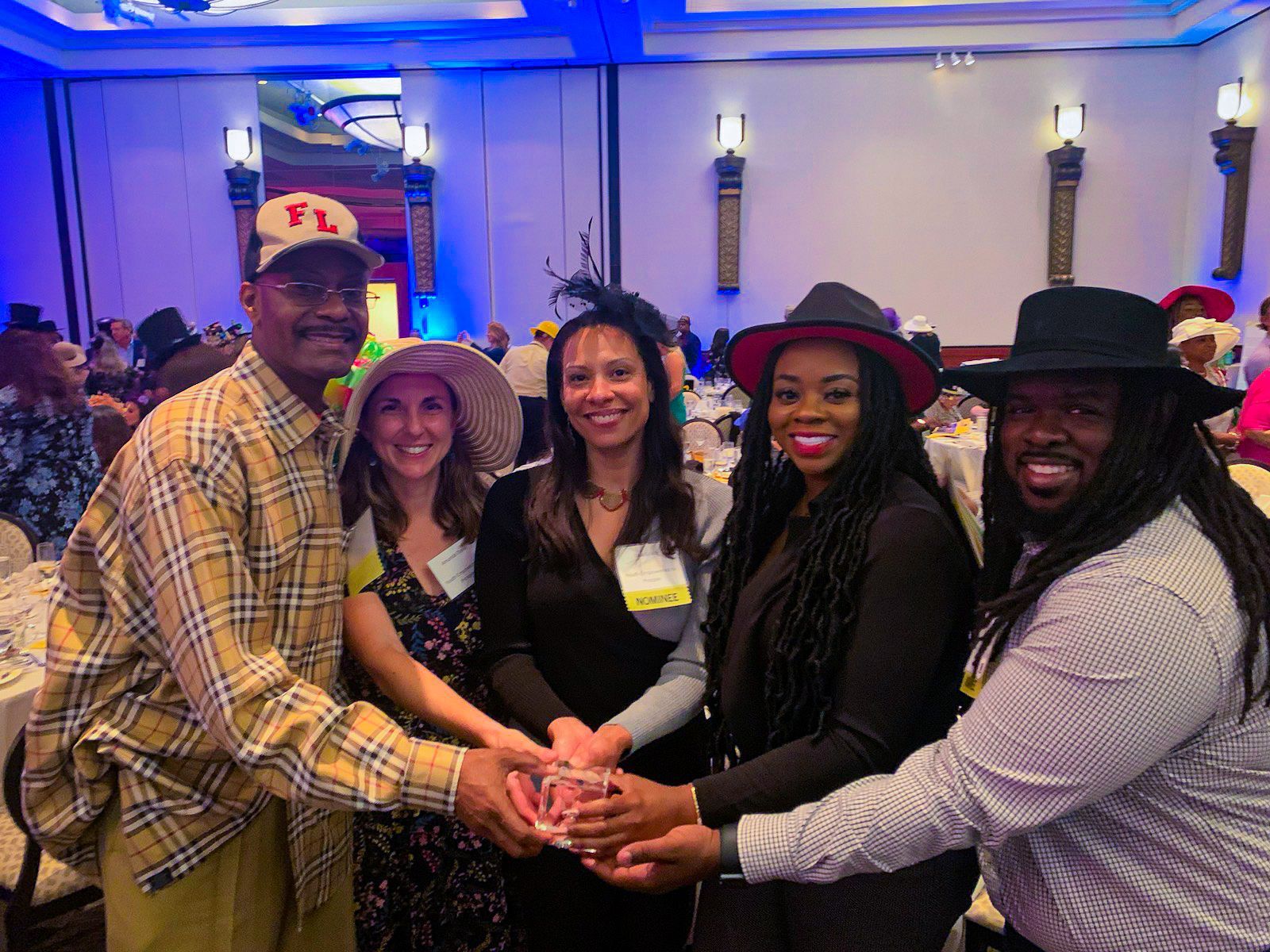 Group of people hold award and pose for camera