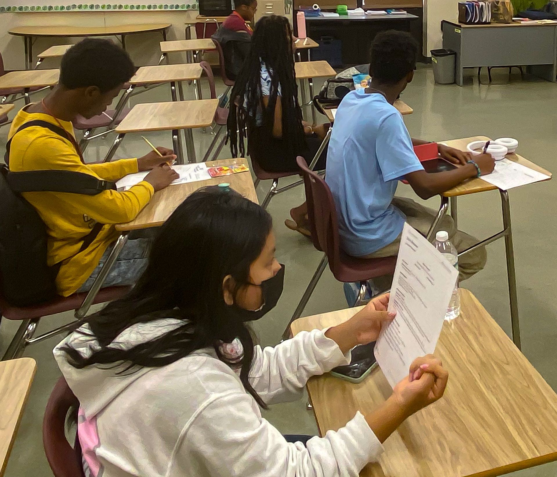 students at desks reviewing papers