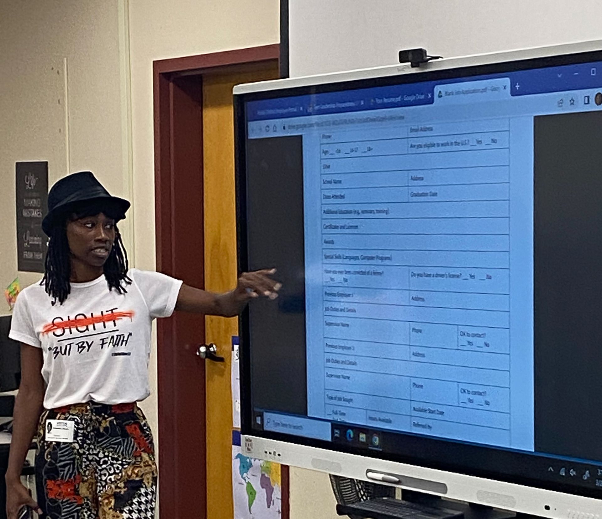 woman pointing something out on large screen in front of class