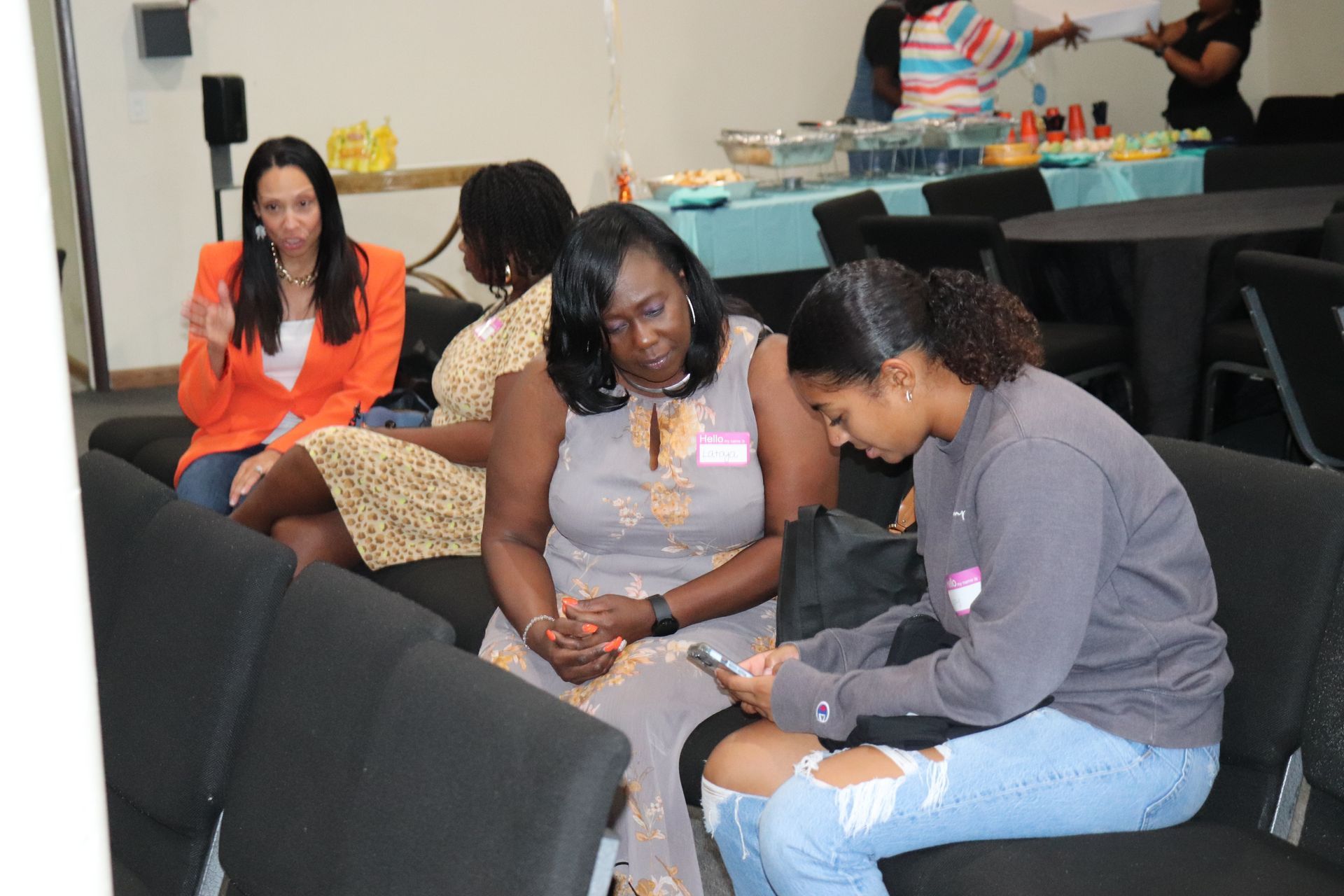 Two women sitting looking at cell phone together