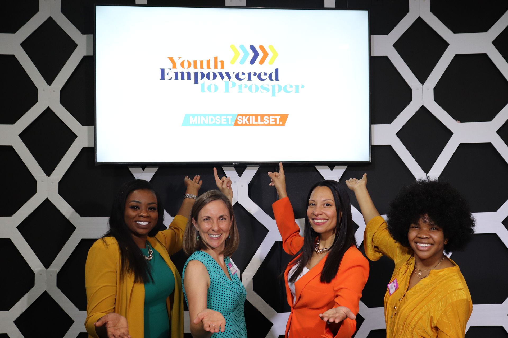 Four women pointing at 