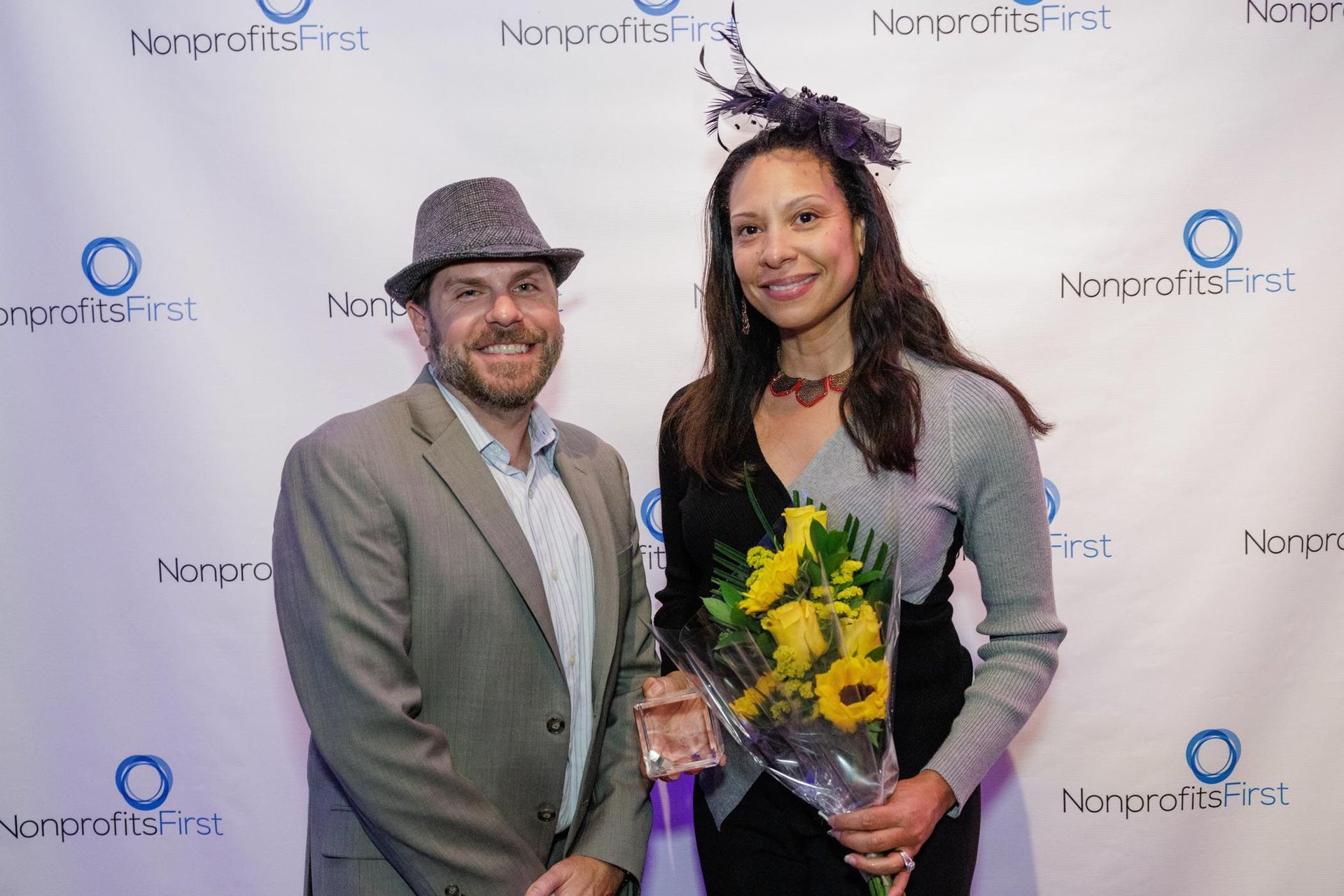 Man with hat and woman with flowers pose for camera