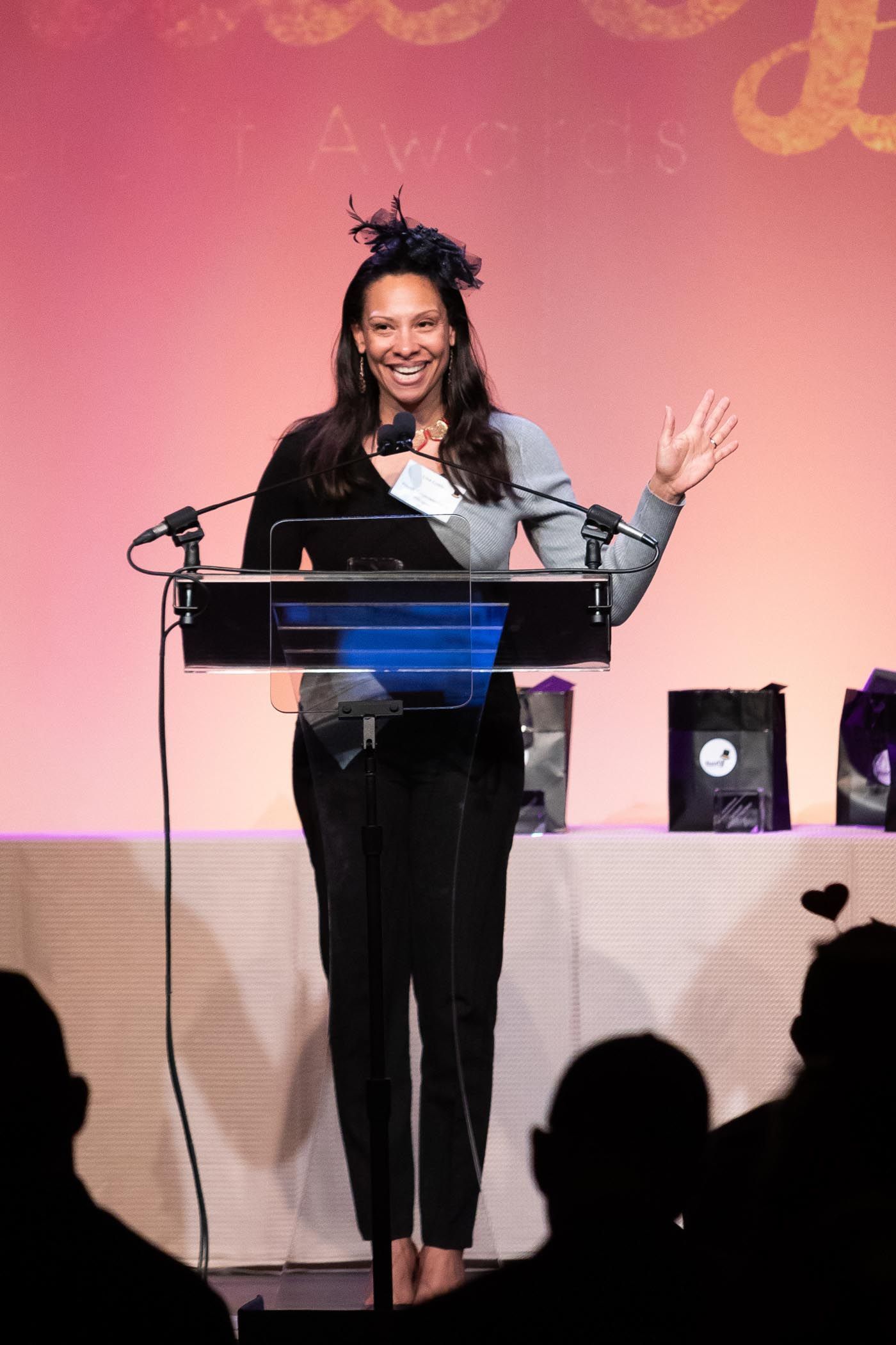 woman in hat stands at podium