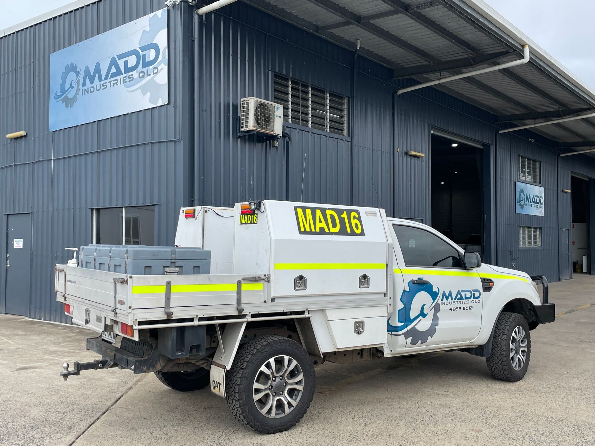 A white truck is parked in front of a building.