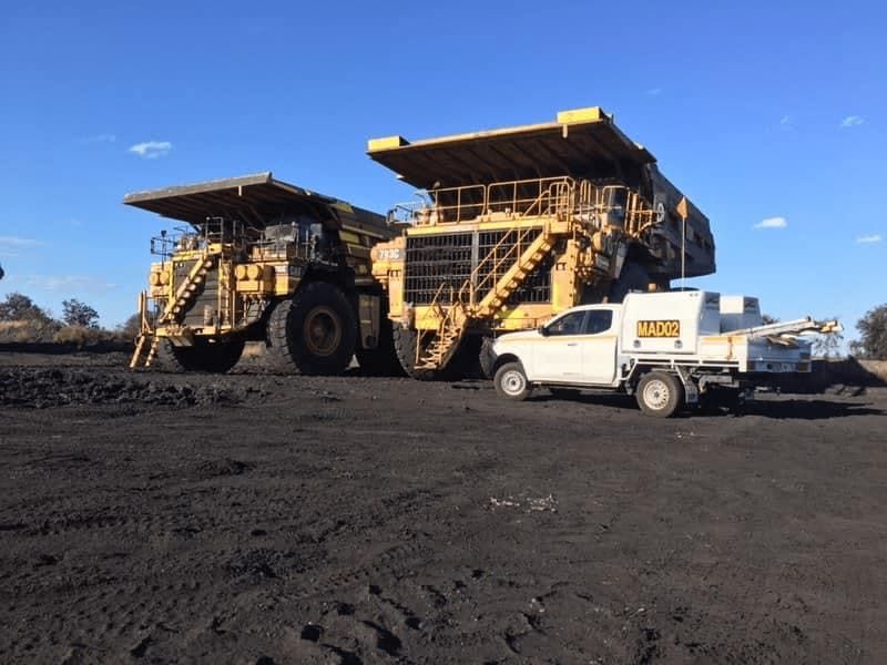 Tipper Trucks and Service Vehicle Parked on Mining Site — MADD Industries in Paget, QLD