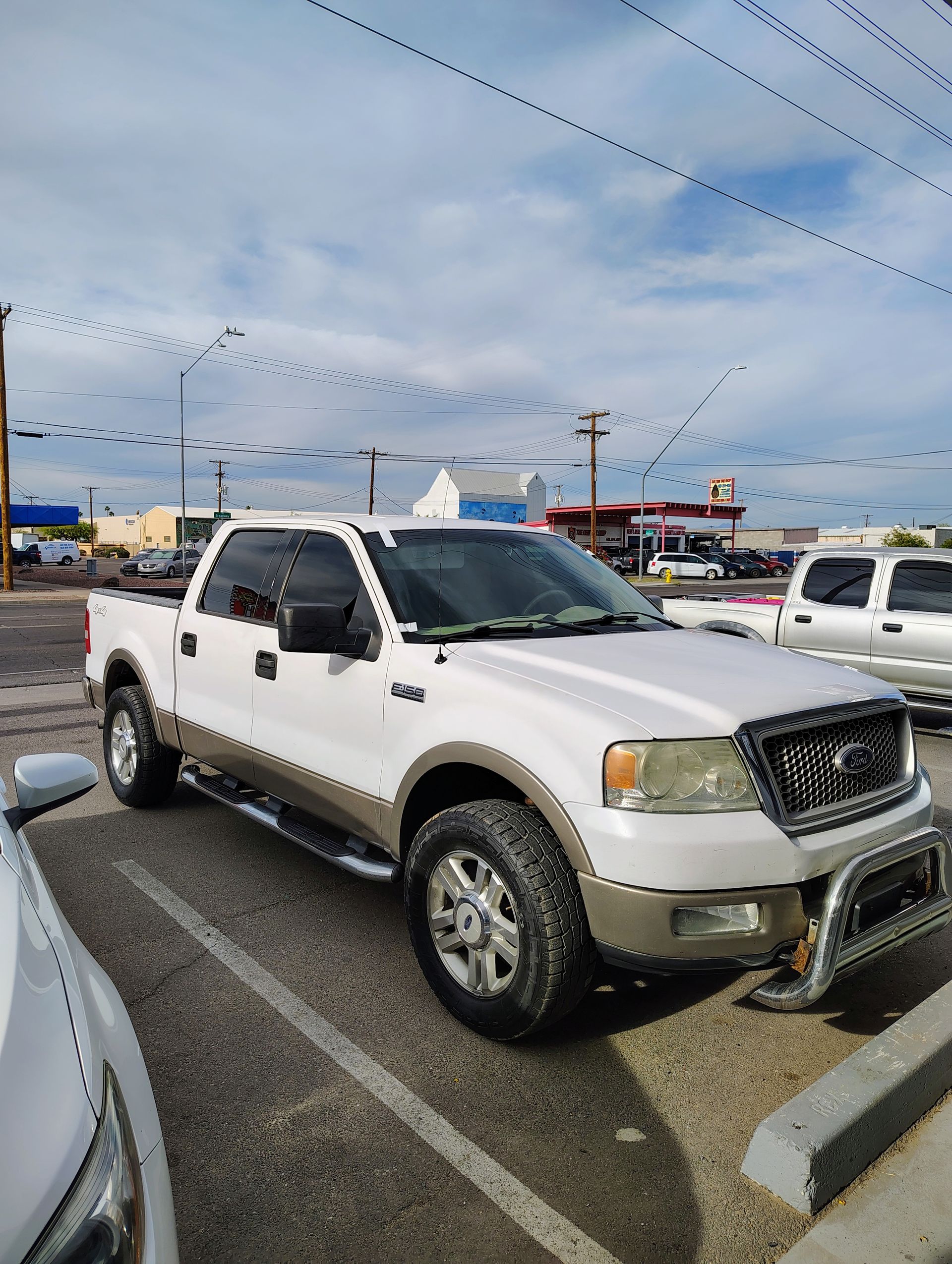 A white pickup truck is parked in a parking lot.