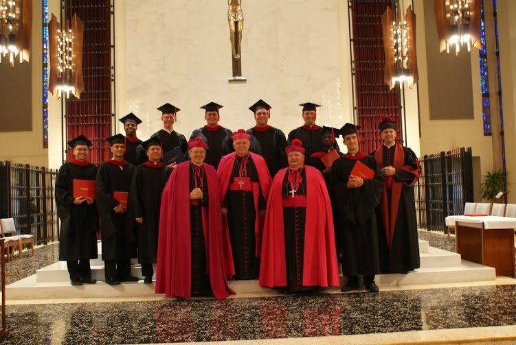 Graduados del seminario posando para una foto en el altar con líderes espirituales.