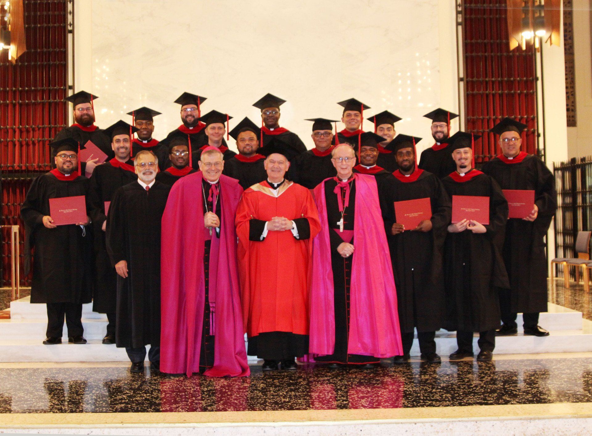 Seminary graduates posing for a photo at the alter with spritual leaders. 