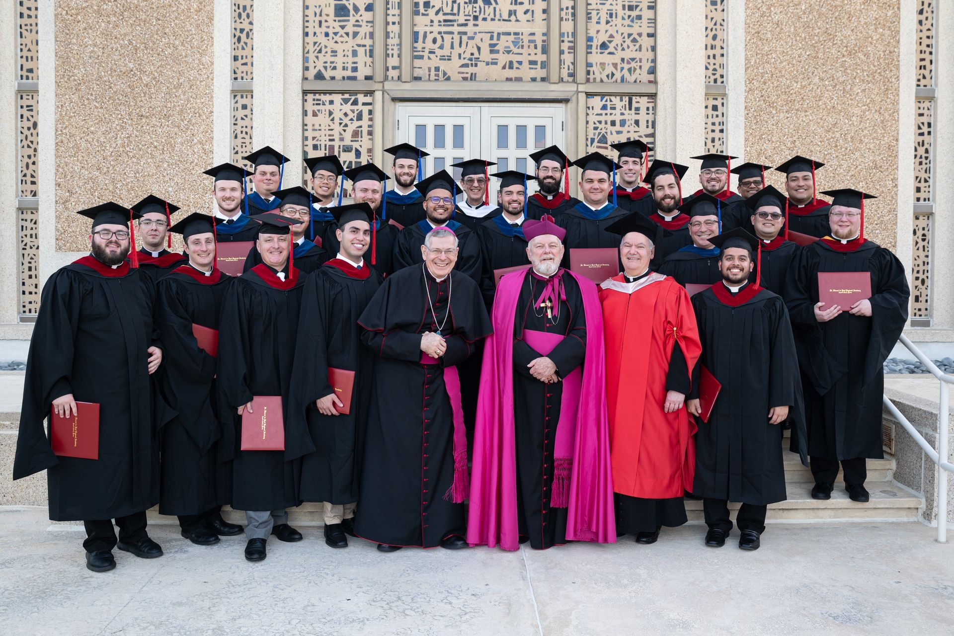 Three Seminary Graduates standing next to the Rector. 