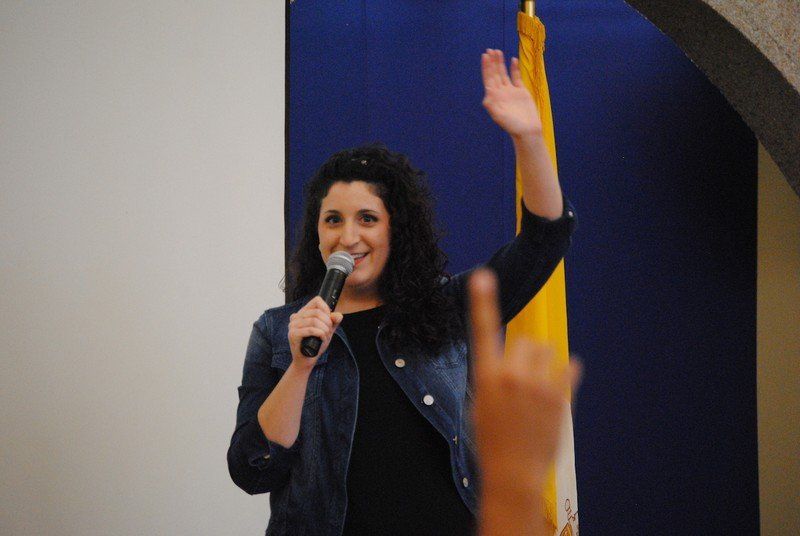 Woman with arm raised speaking at a session.