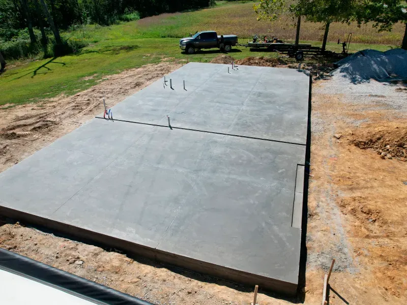 A large concrete slab is sitting in the middle of a dirt field.