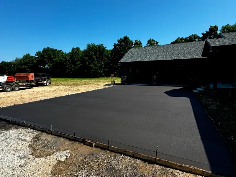 A concrete driveway is being built in front of a house.