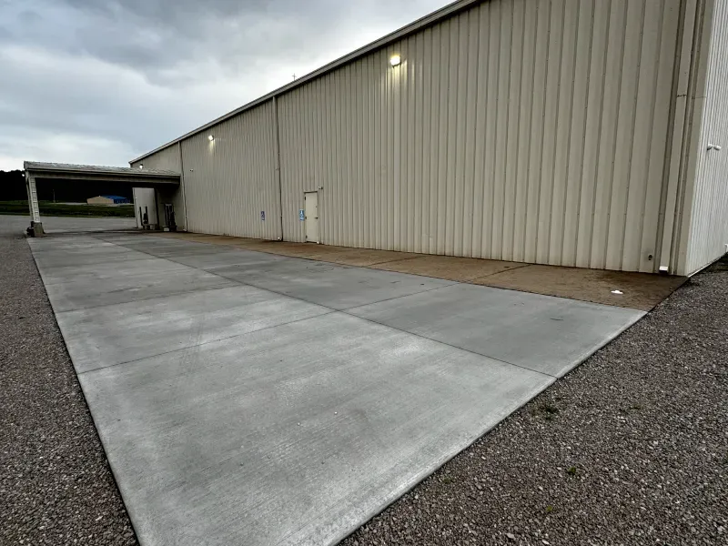A large building with a concrete driveway in front of it.