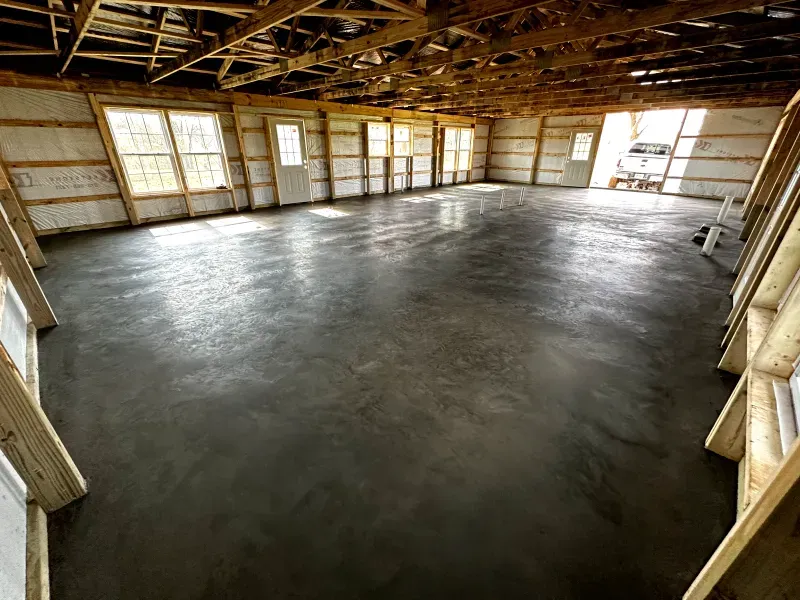 A large room with a concrete floor and a lot of windows.