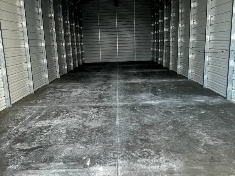 An empty garage with a concrete floor and white walls.