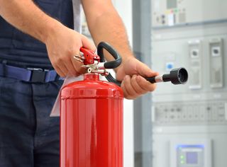 Fire Extinguishers Sales — A Man Holding A Fire Extinguisher in St. Louis, MO