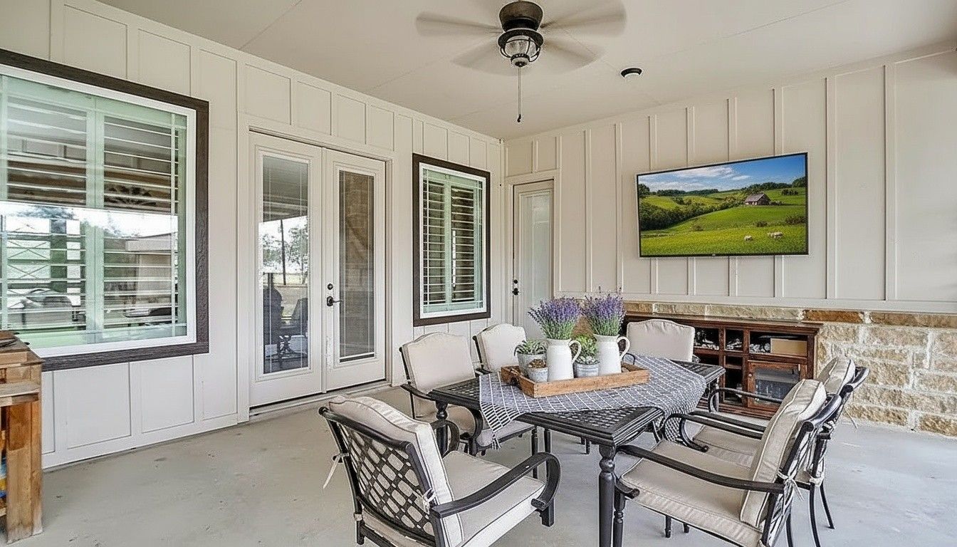 A patio with a lot of furniture and lights at night.