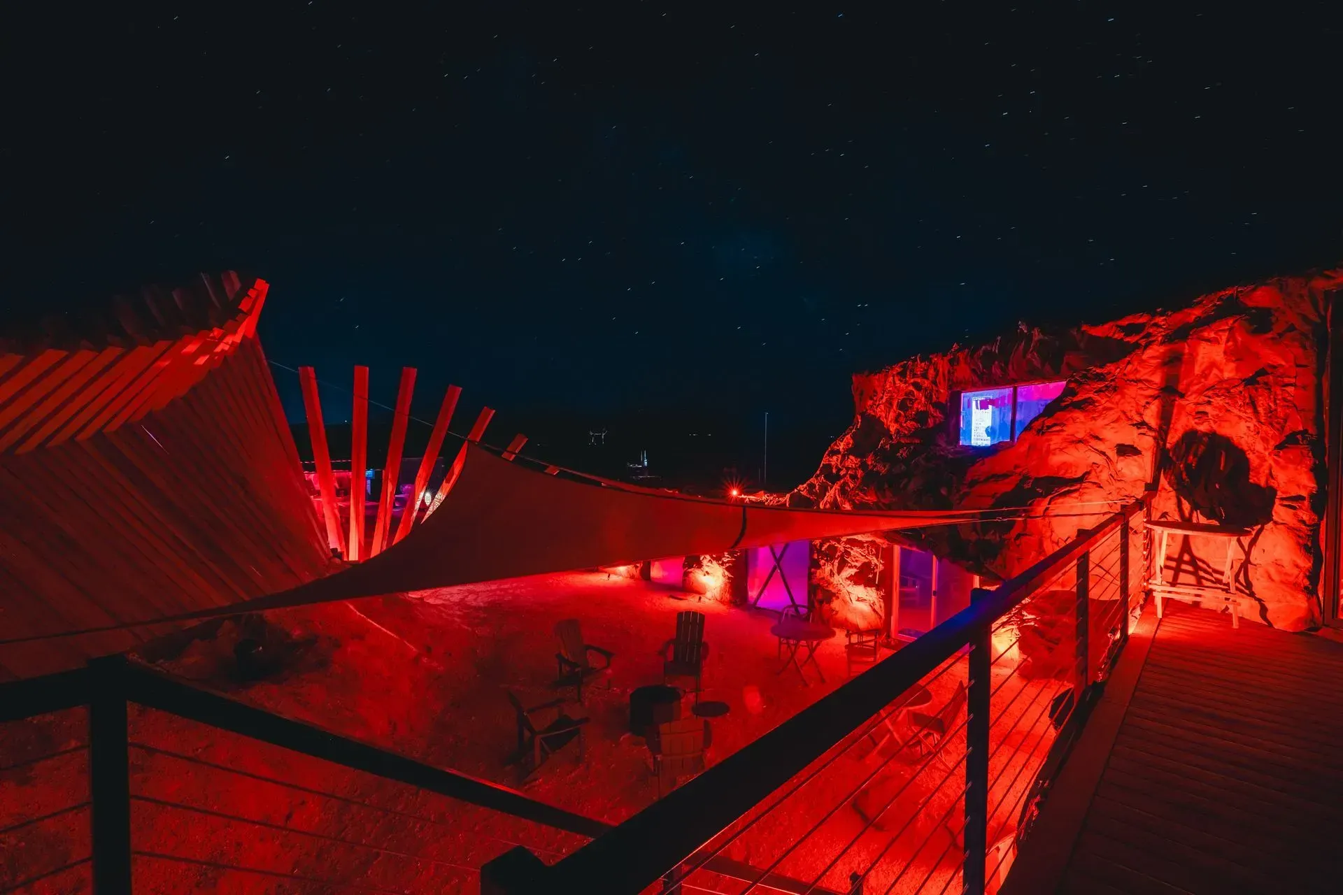 A group of people are sitting on a balcony at night.