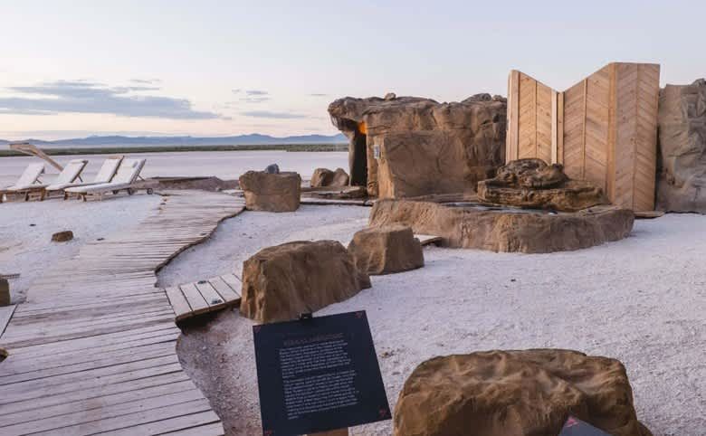 A wooden walkway surrounded by rocks and a sign.