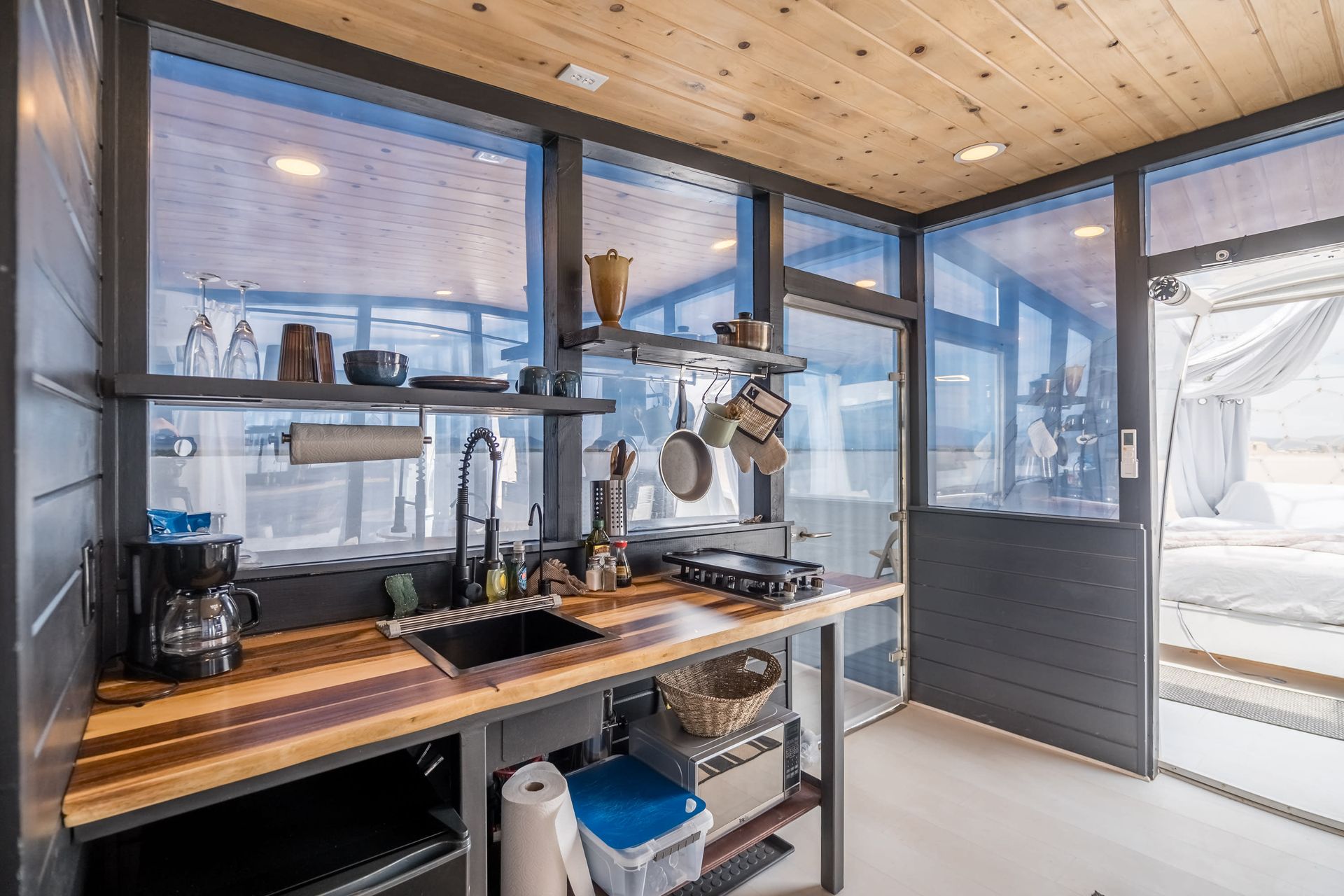 A kitchen with a sink and a lot of windows.