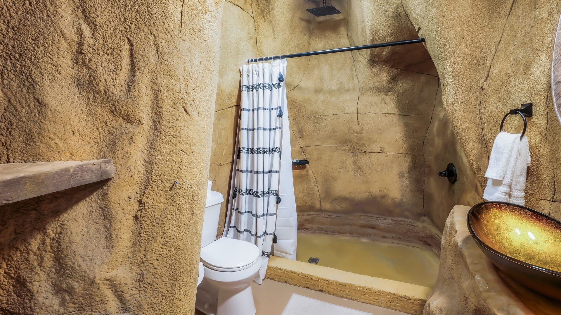 A bathroom with a toilet , sink and shower.