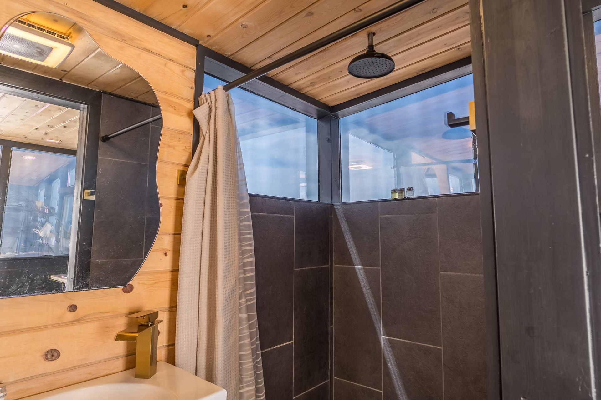 A bathroom with a sink , mirror , and shower.