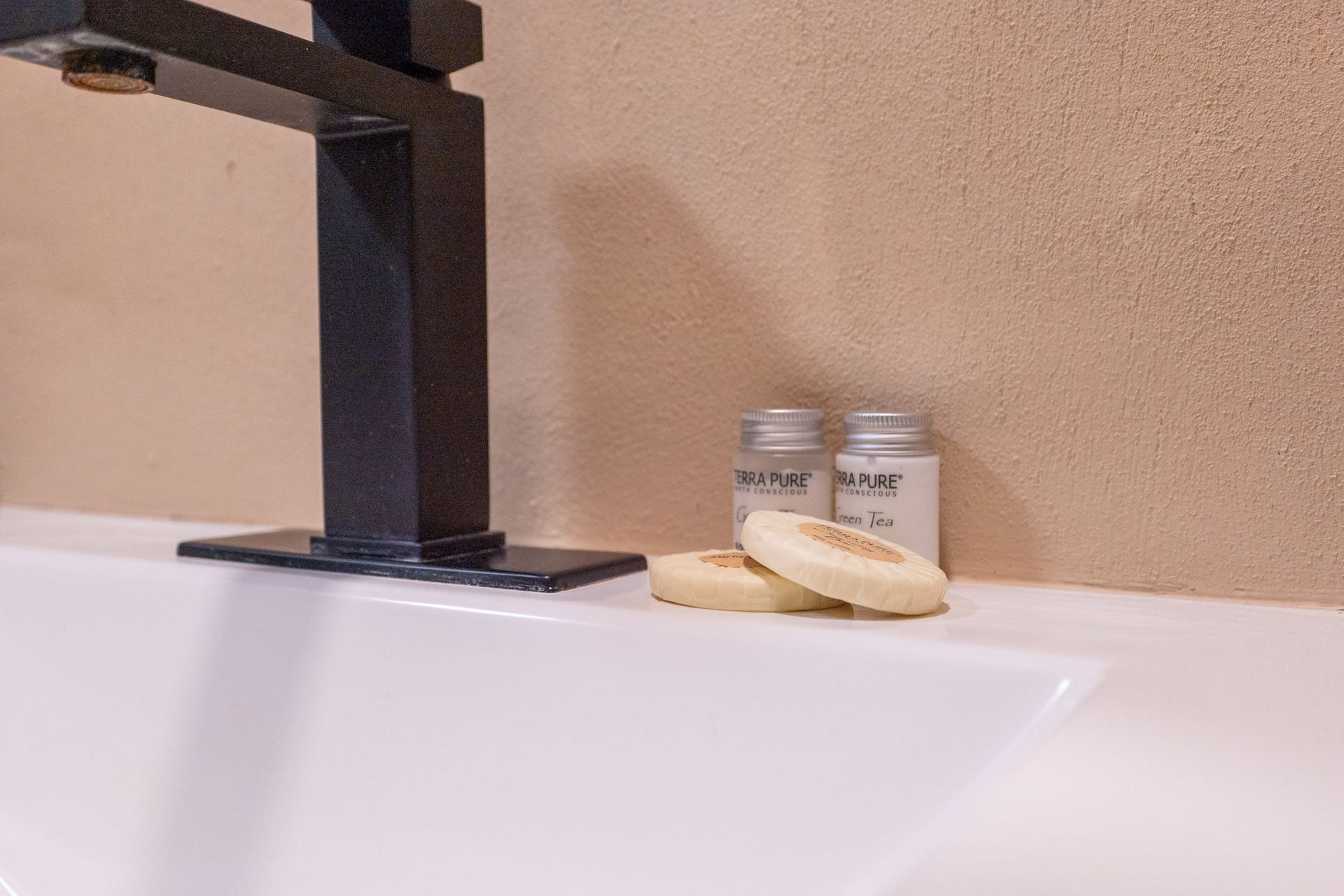 A bathroom sink with soap and lotion on it.