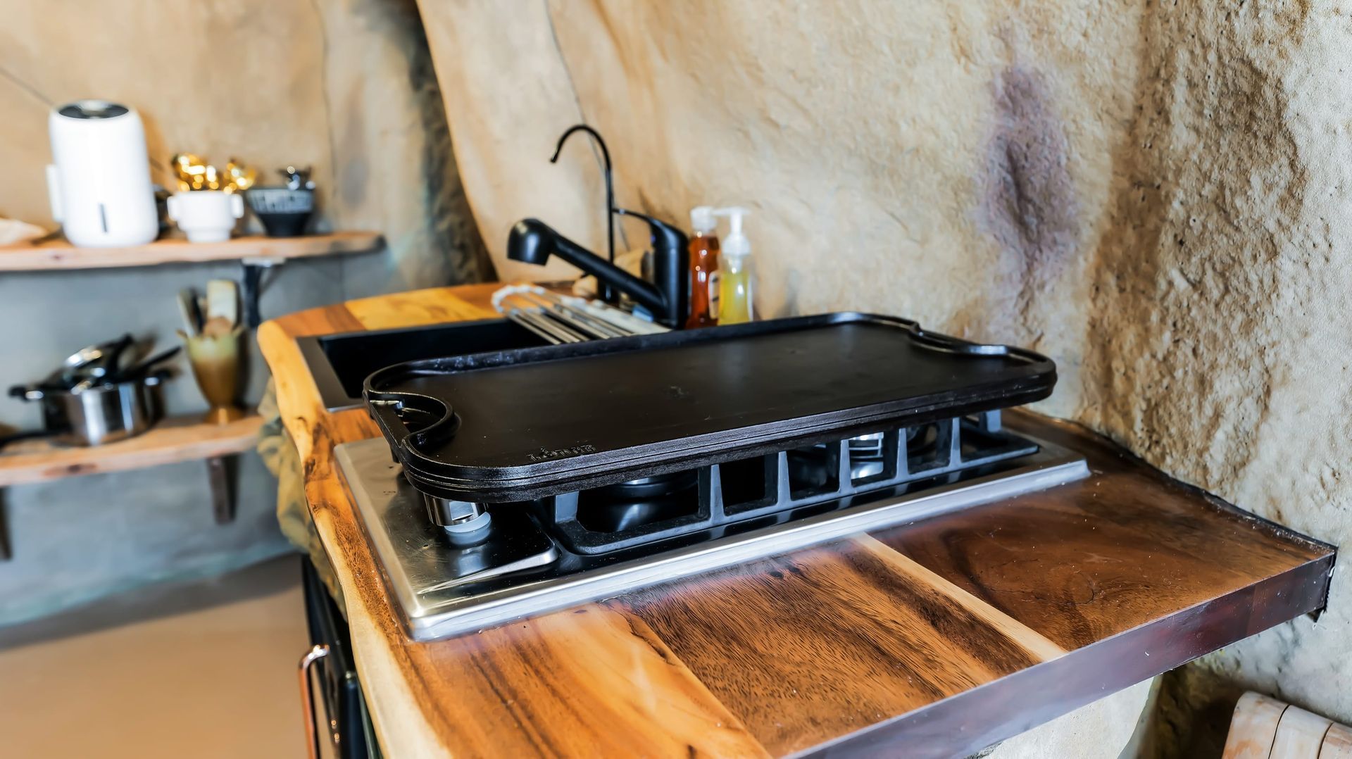 A kitchen with a stove , sink , and a griddle.