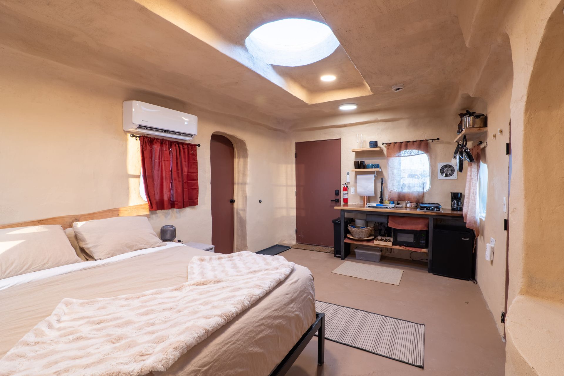 A bedroom with a bed , desk , and window.