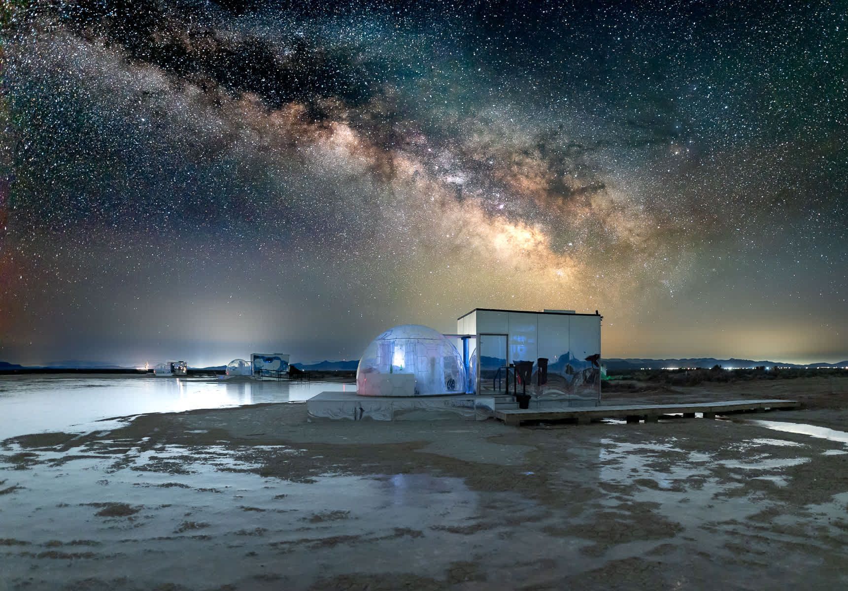 A house on a beach under a starry night sky