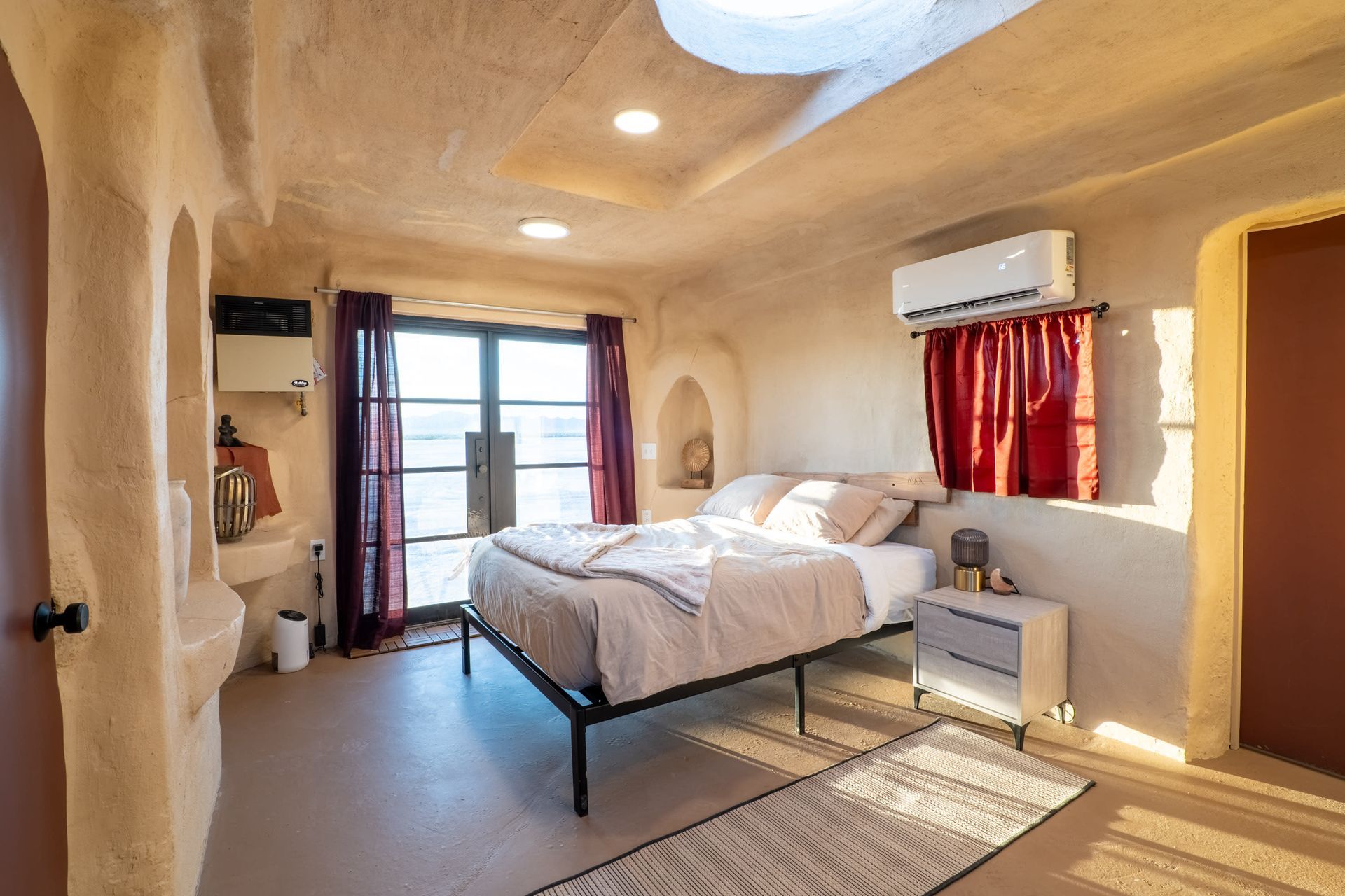 A bedroom with a bed , nightstand , and window.
