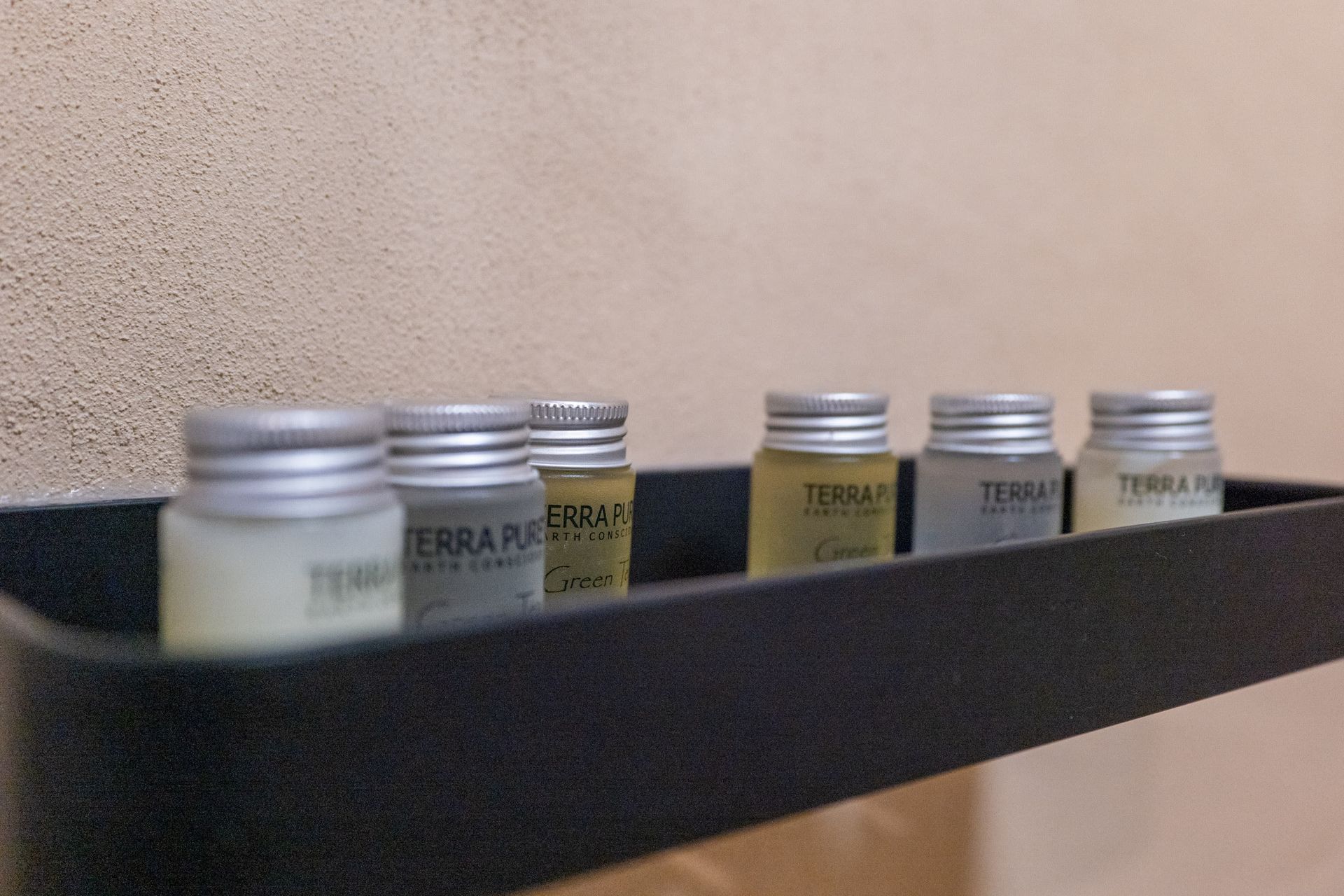 A shelf with bottles of shampoo and conditioner on it.