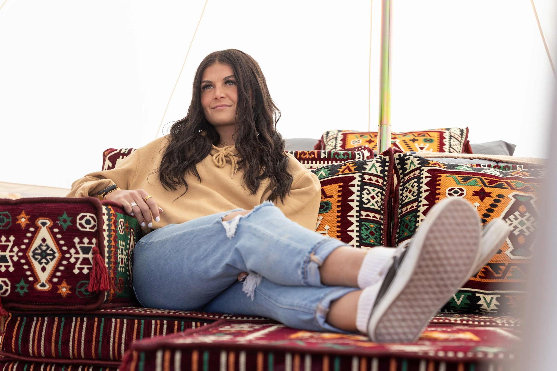 A woman is sitting on a couch with her feet up.