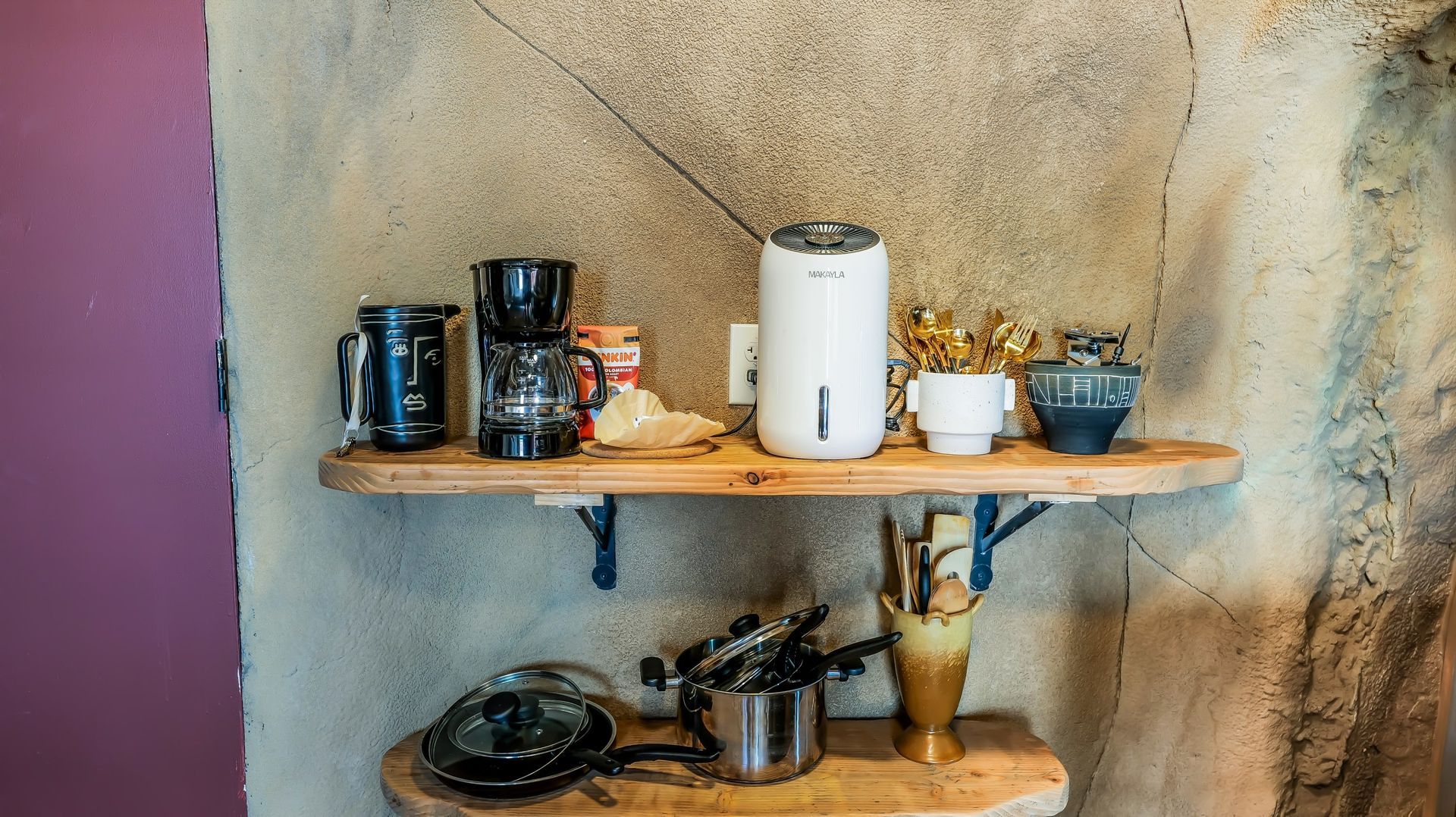 A wooden shelf with a variety of kitchen utensils on it.