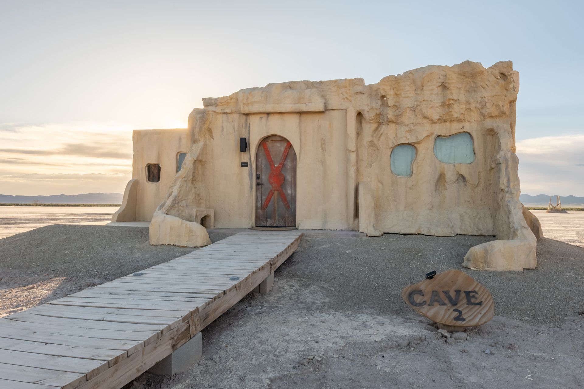 A cave with a wooden walkway leading to it