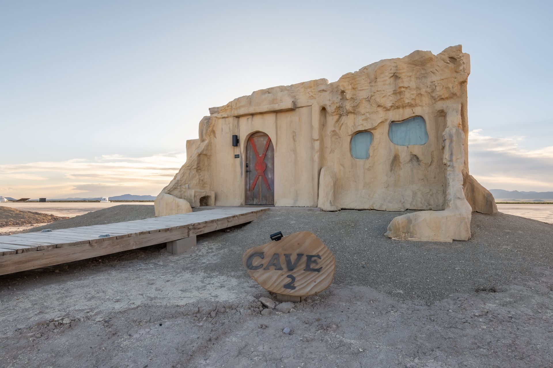 A cave with a wooden sign in front of it.