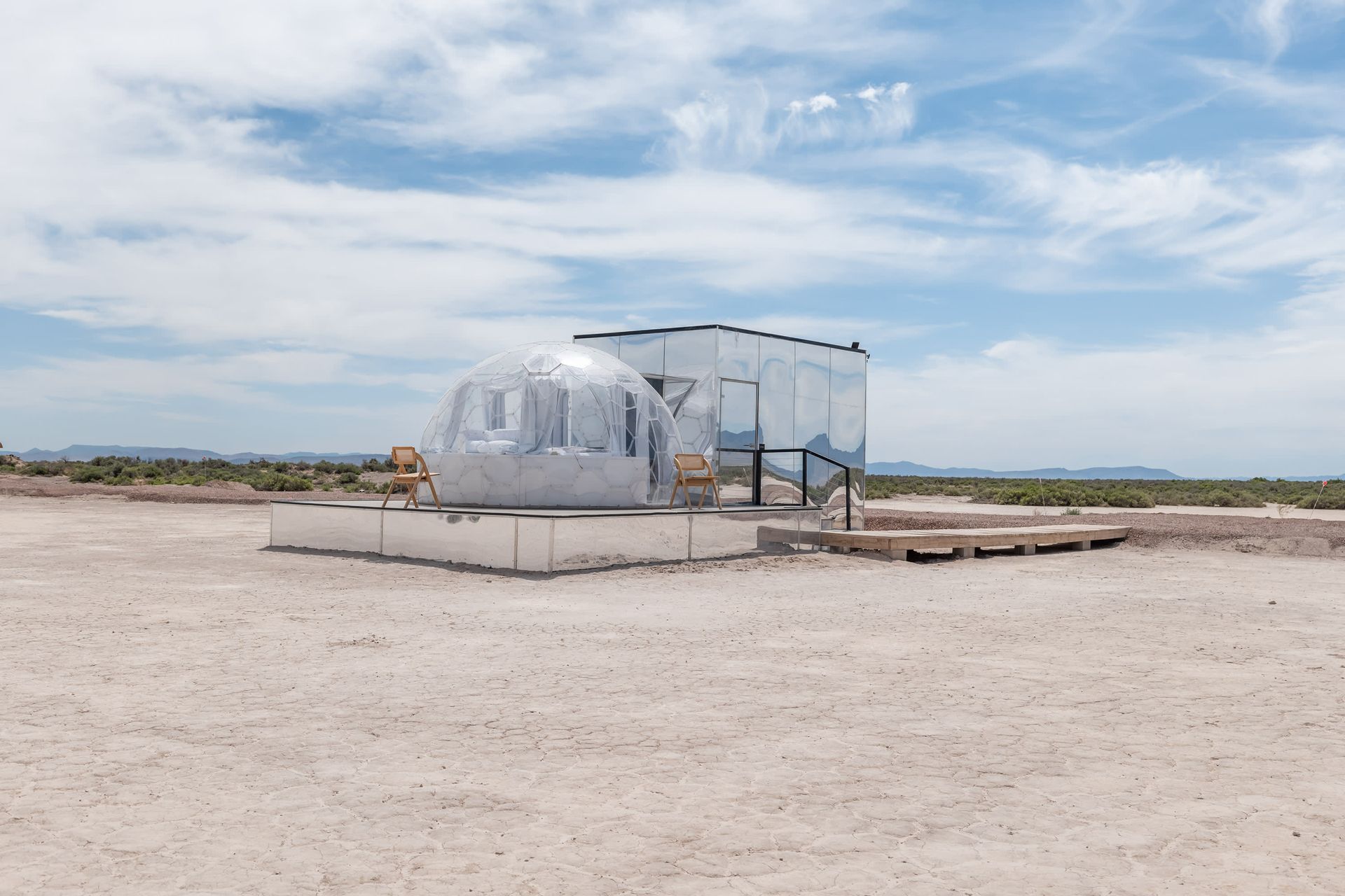 A bubble tent is sitting in the middle of a desert.