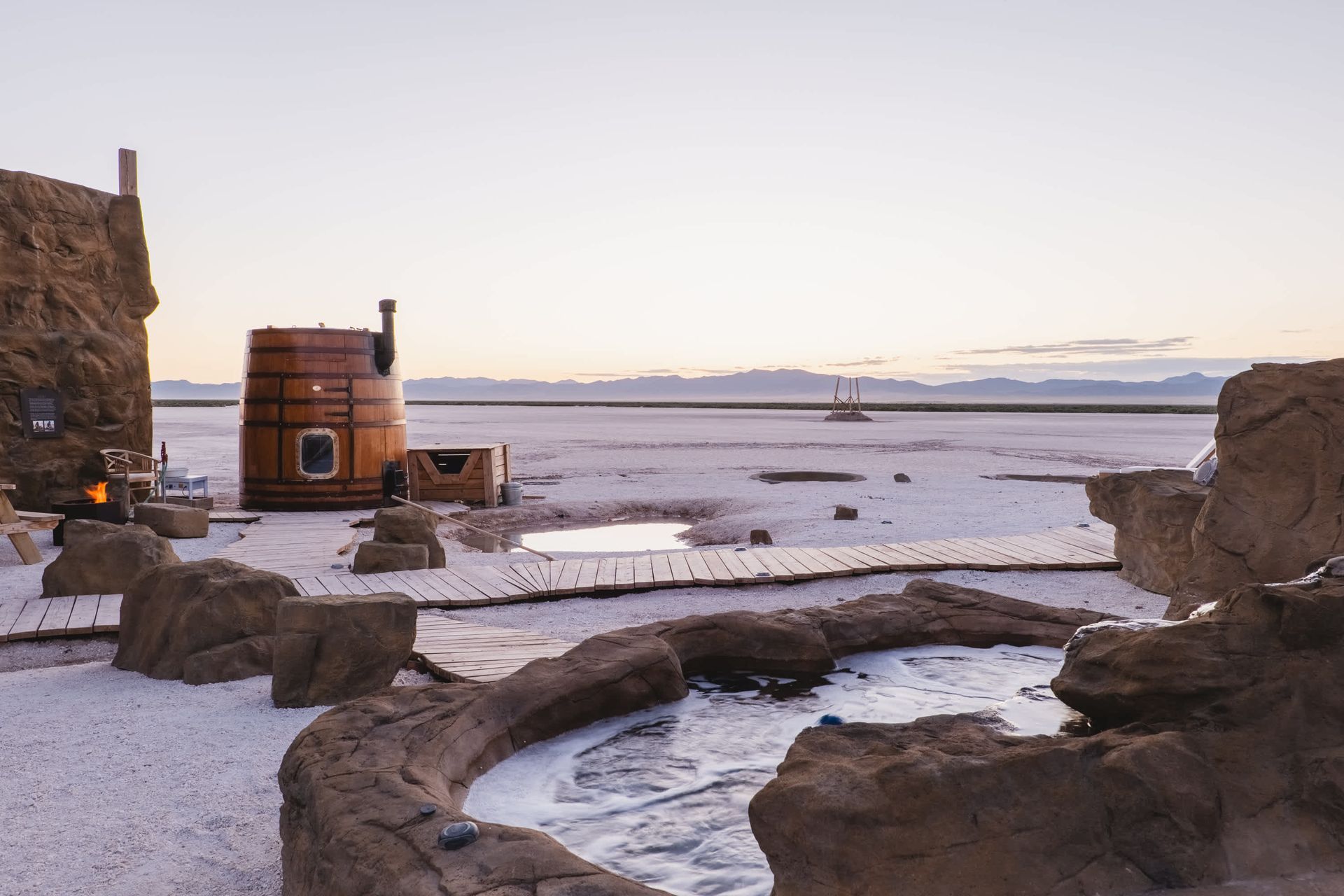 A hot tub surrounded by rocks in the middle of a desert