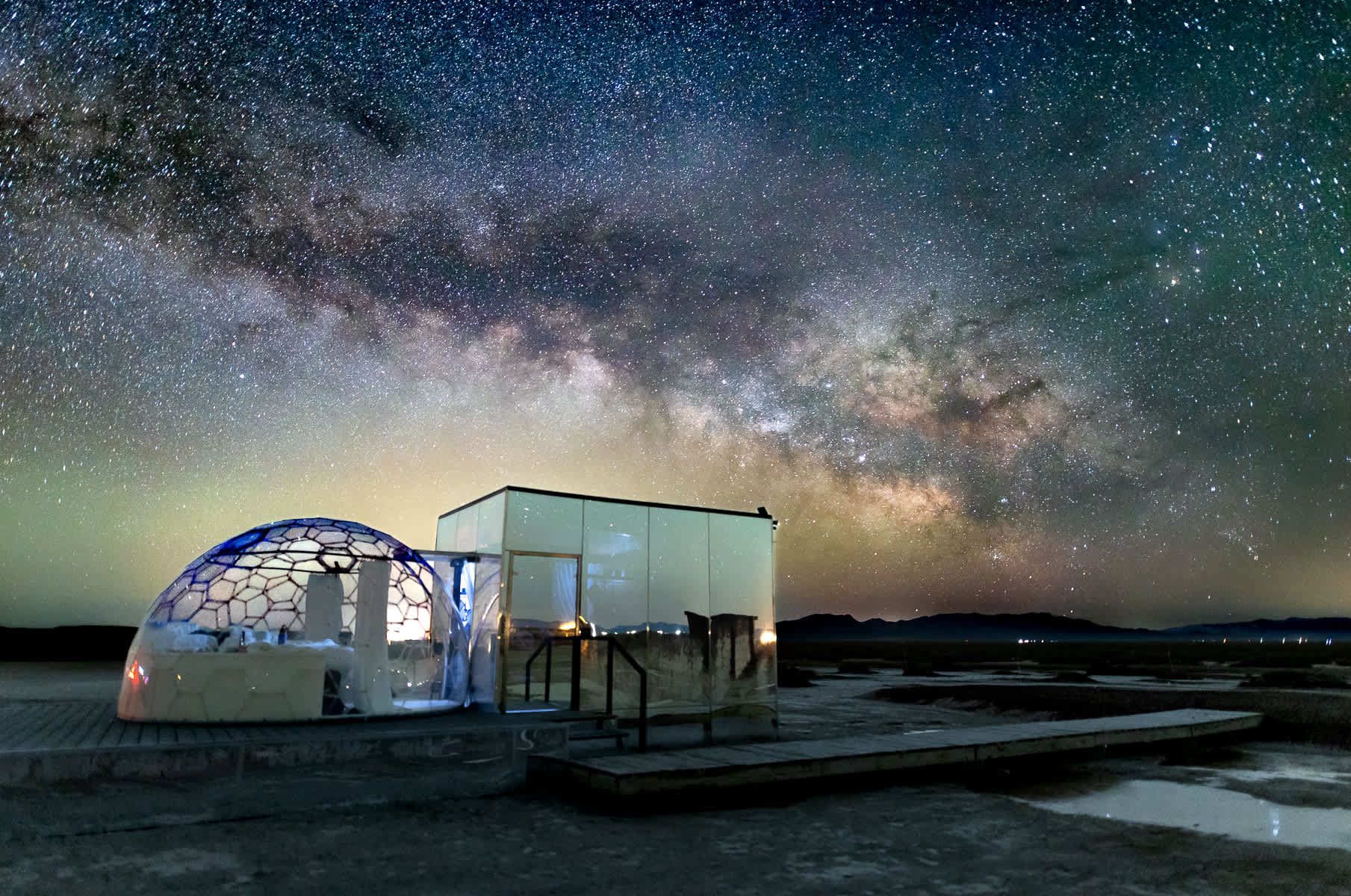 A dome is sitting on top of a dock under a starry sky.