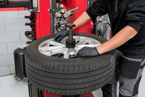 Professional mechanic inspecting and rotating vehicle tires.