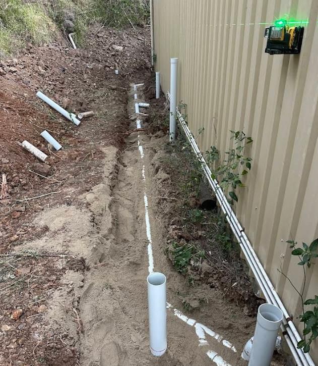 Trench With White Plumbing Pipes Along a Wall — Vantage Plumbing and Drainage In Helensvale, QLD