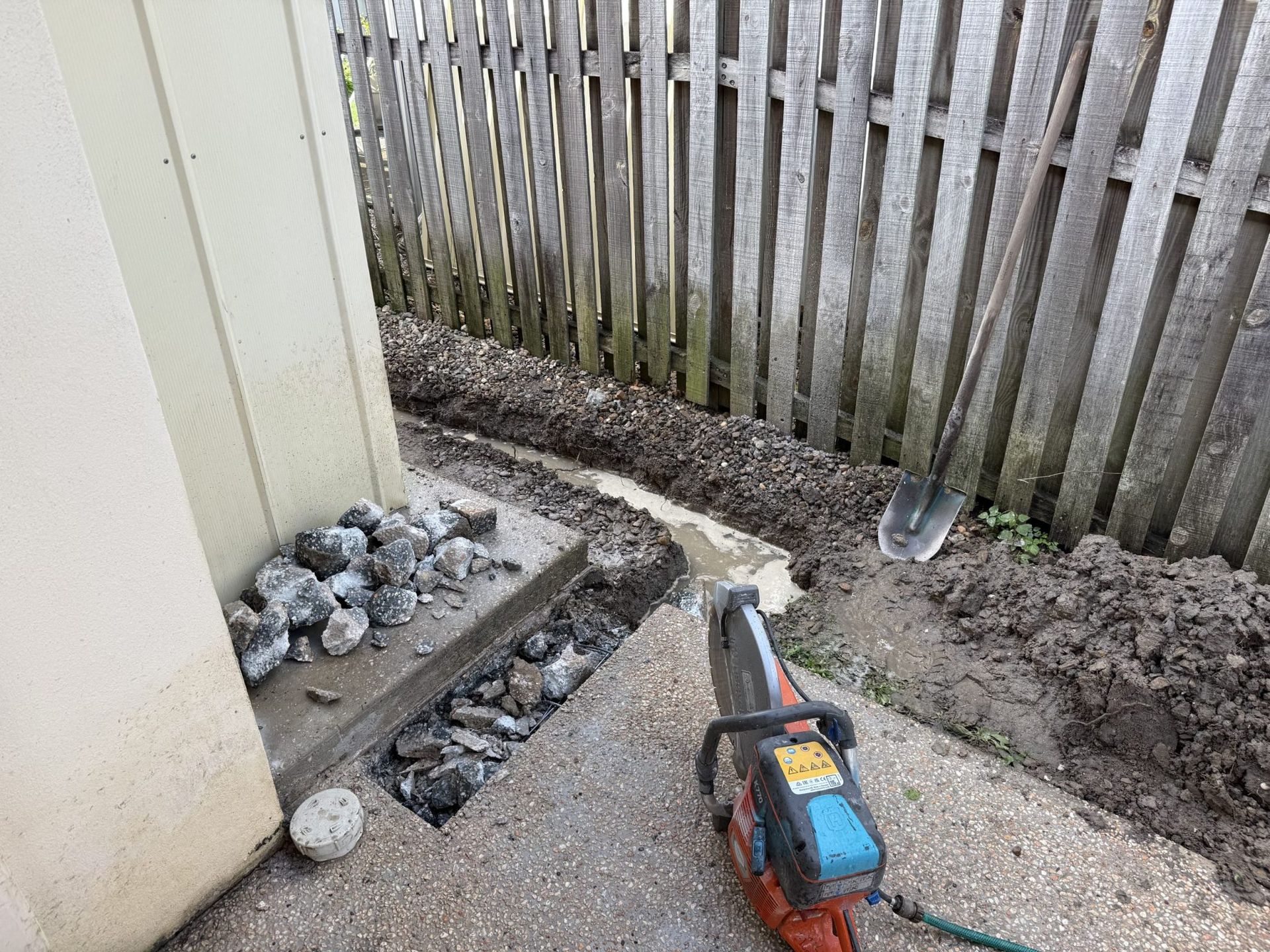 Trench Dug Along a Wall and Fence — Vantage Plumbing and Drainage In Pacific Pines, QLD