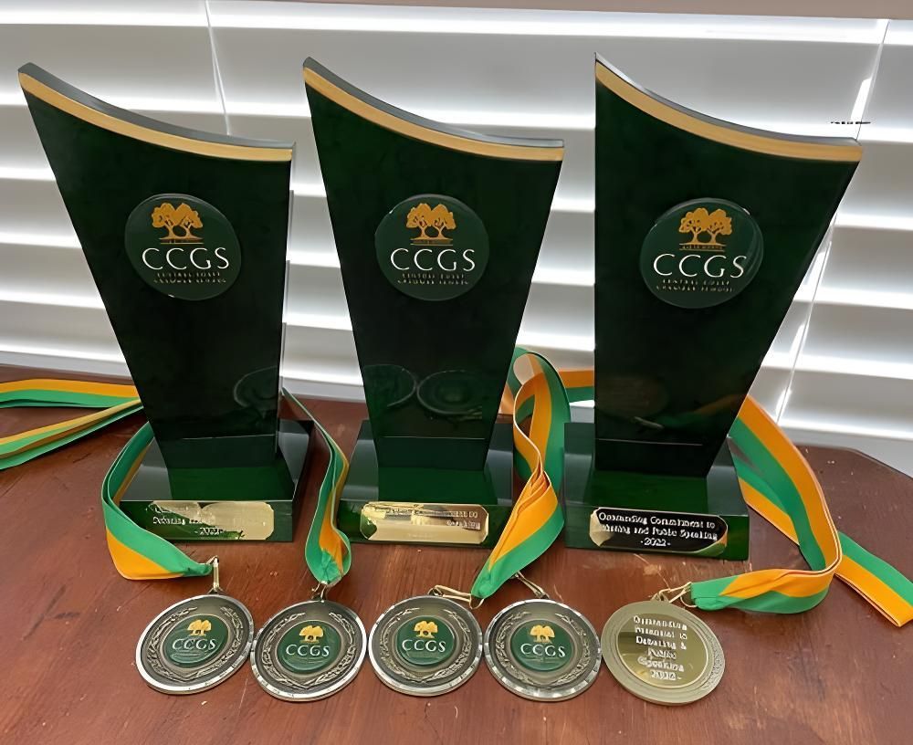 Three Trophies and Medals Are Sitting on a Wooden Table — Framing Alternative in Erina Heights, NSW