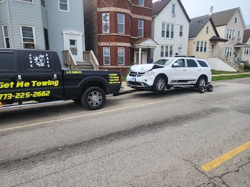 A get me towing truck is towing a white suv.