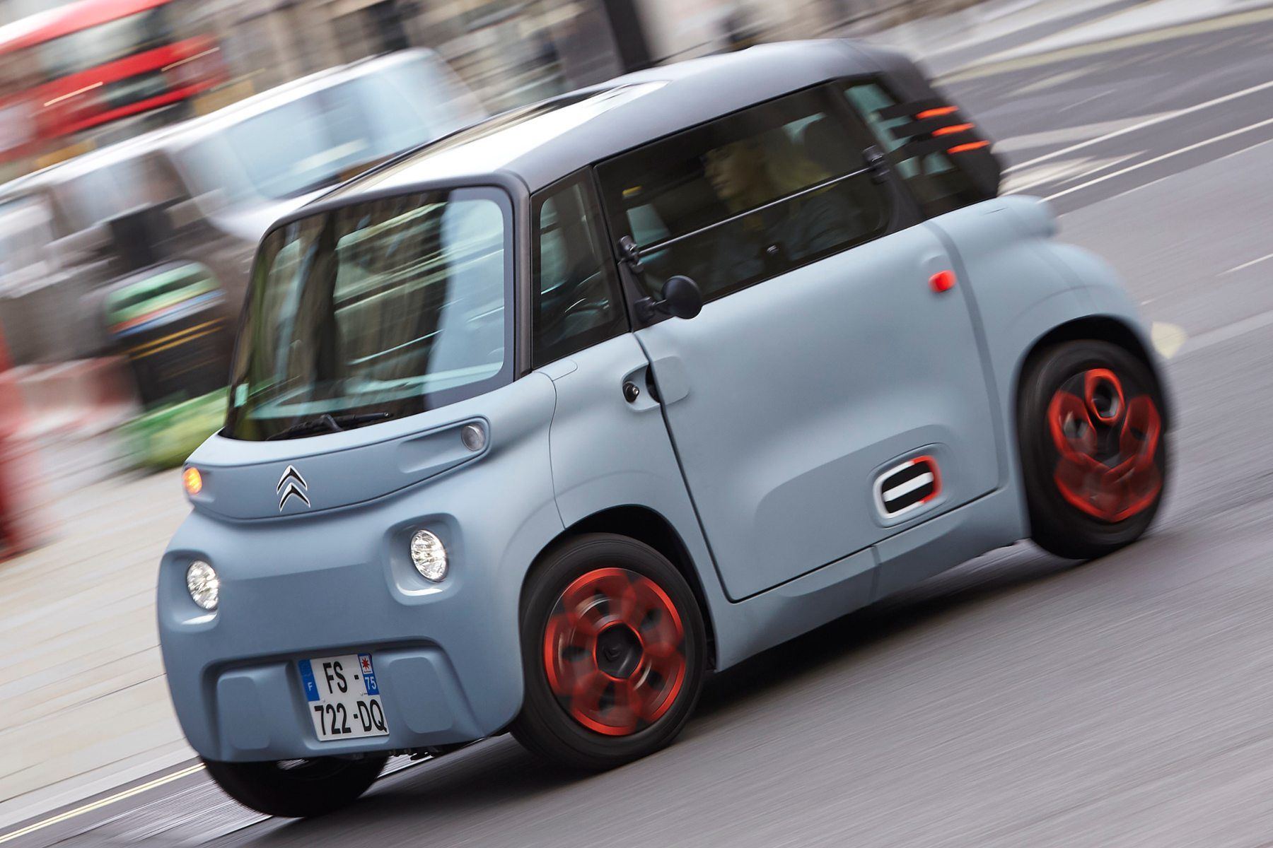 a  electric Citroen Ami is driving down a city street