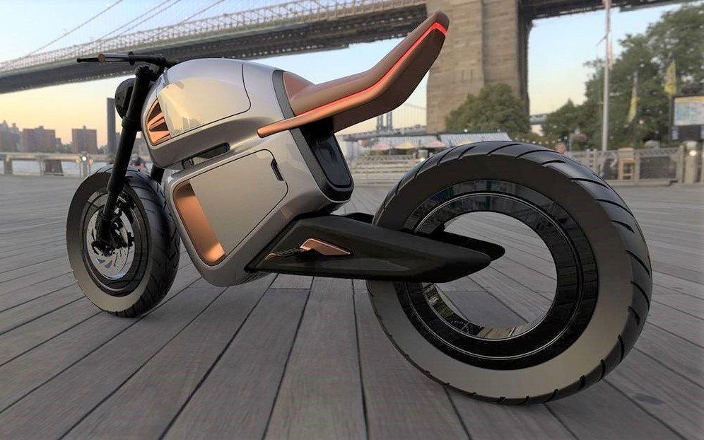 An electric motorcycle is parked on a wooden deck in front of a bridge.
