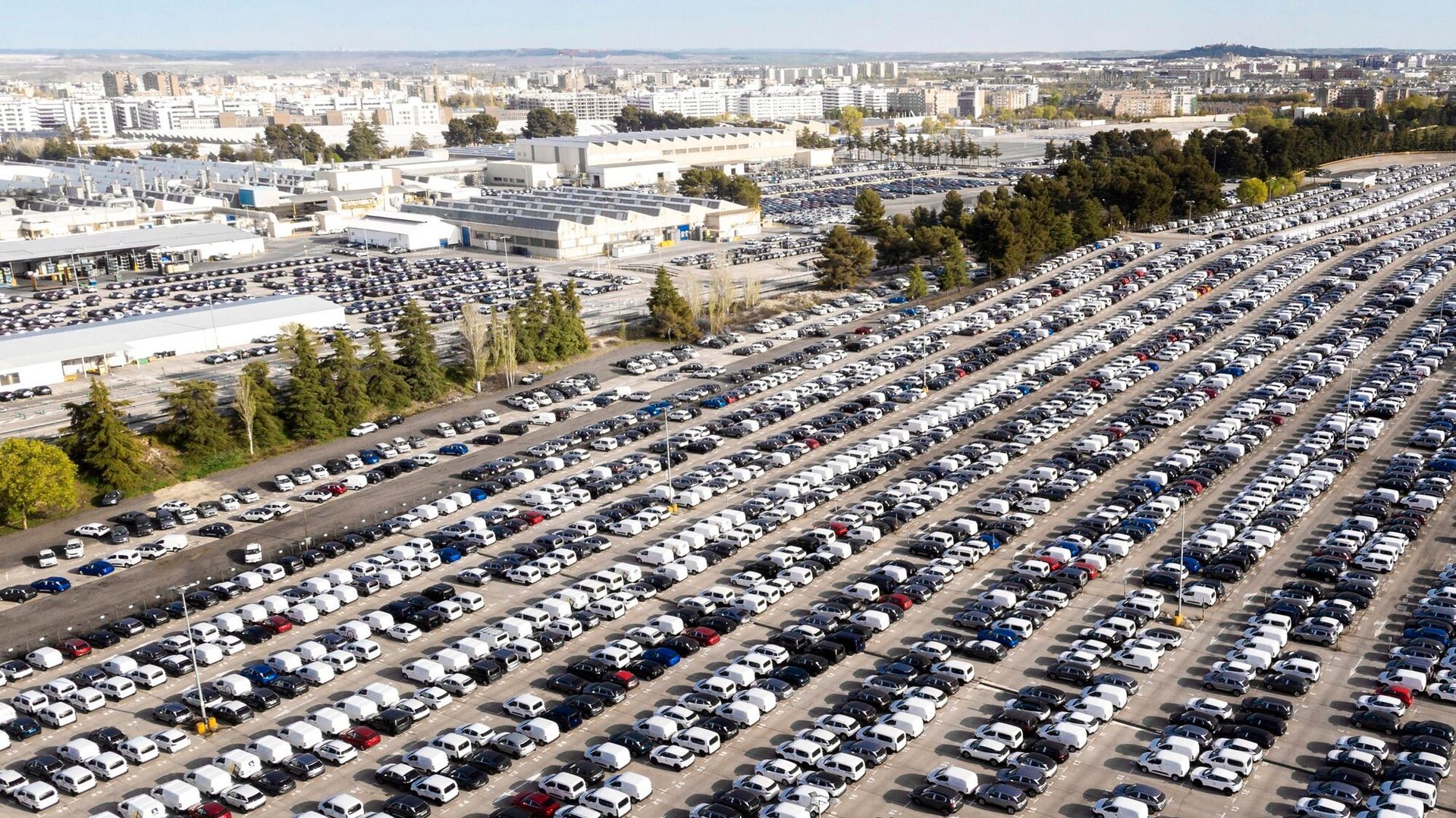 An aerial view of a parking lot filled with lots of cars.